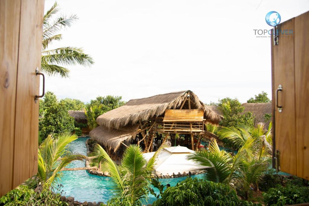 Dak LakLang's Pá Mé - Homestay - Bungalow - Camping Krông Pắk, Buôn Mê Thuột, Đắk Lắk, Việt Nam的一个带游泳池的度假胜地和一个茅草屋顶的度假胜地