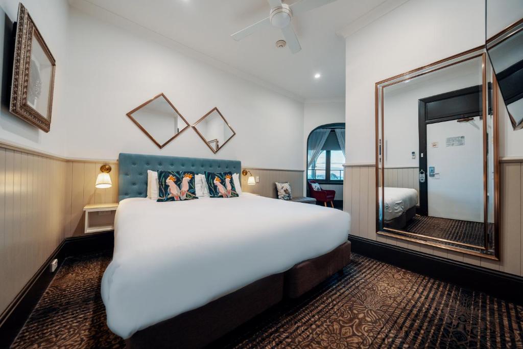悉尼克雷蒙角曼诺尔酒店的配有一张大床和镜子的酒店客房