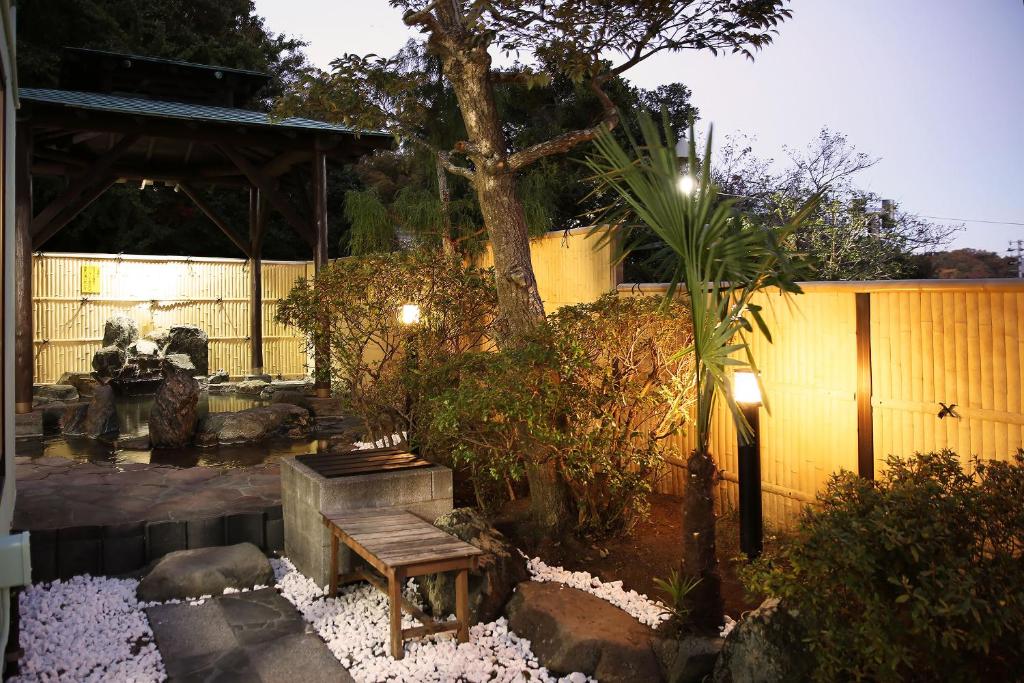磐城美风之宿日式旅馆的花园,花园内有长凳、树和围栏