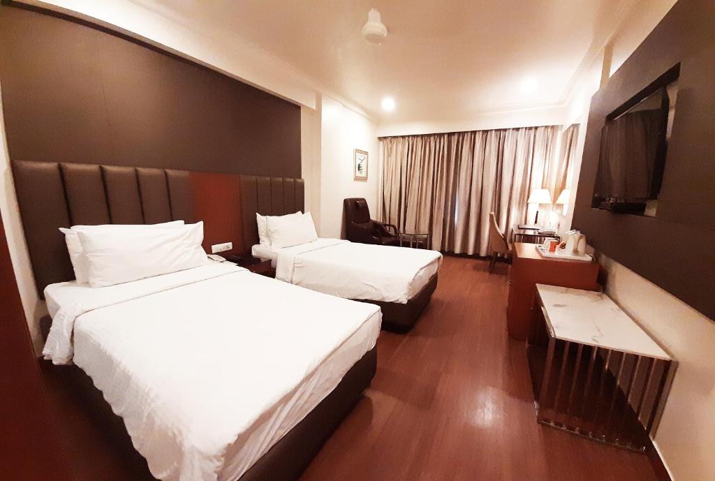 维杰亚瓦达Fortune Murali Park, Vijayawada - Member ITC's Hotel Group的酒店客房设有两张床和电视。