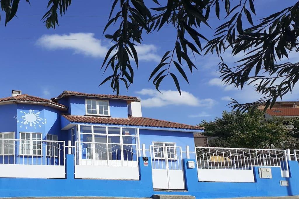 罗德里戈城Ciudad Rodrigo La Casa Azul的蓝色的房子,设有白色的窗户和栅栏