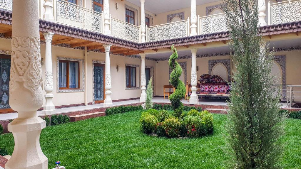 撒马尔罕Jahongir Premium的一座带绿色草坪的房屋的庭院