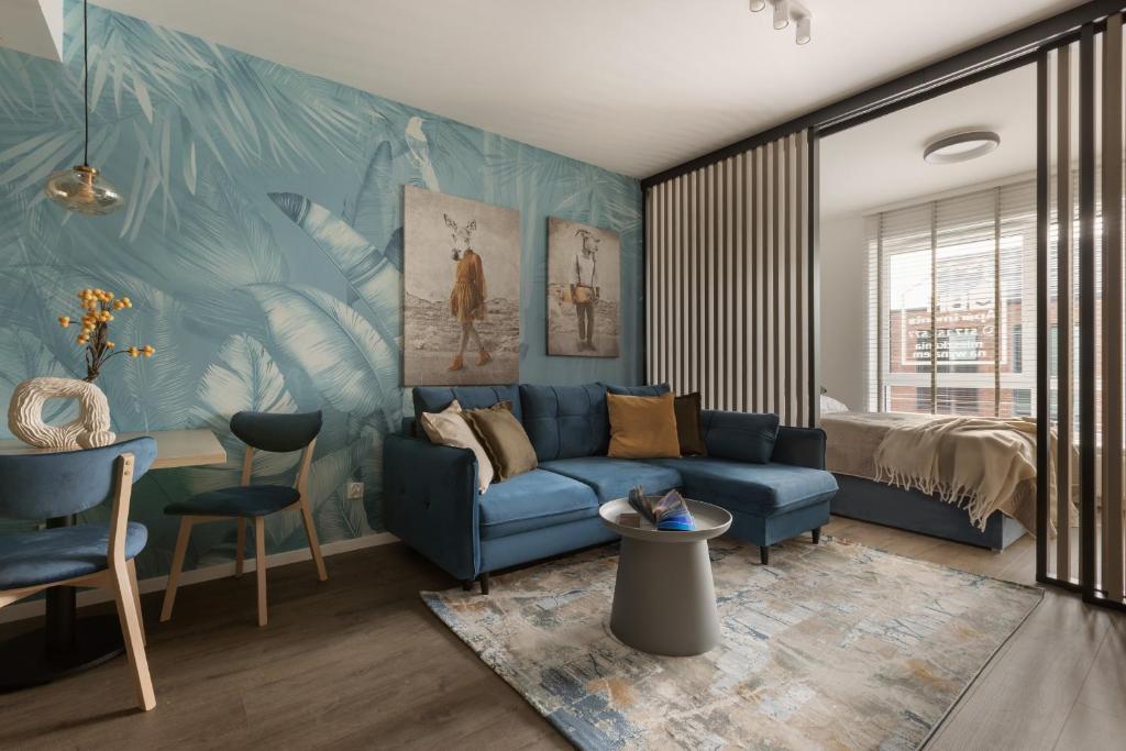 格但斯克Glow Apartments, Gdańsk Śląska 12的客厅配有蓝色的沙发和床。
