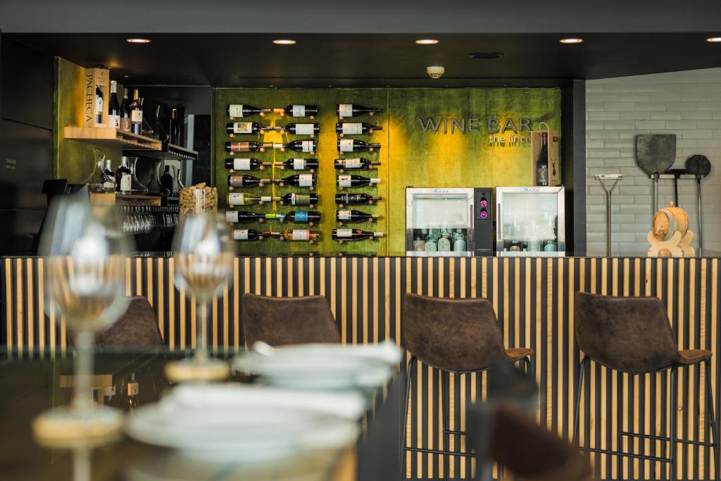 蓬塔德尔加达The Lince Azores的一间带桌椅和葡萄酒架的餐厅