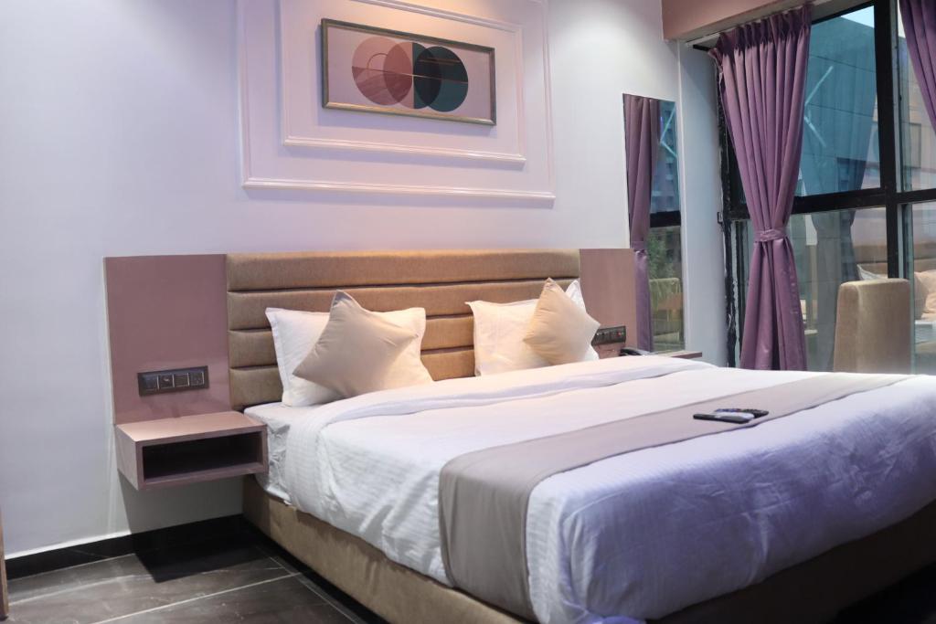 苏拉特Hotel Czar Inn的一间卧室设有一张大床和一个窗户。