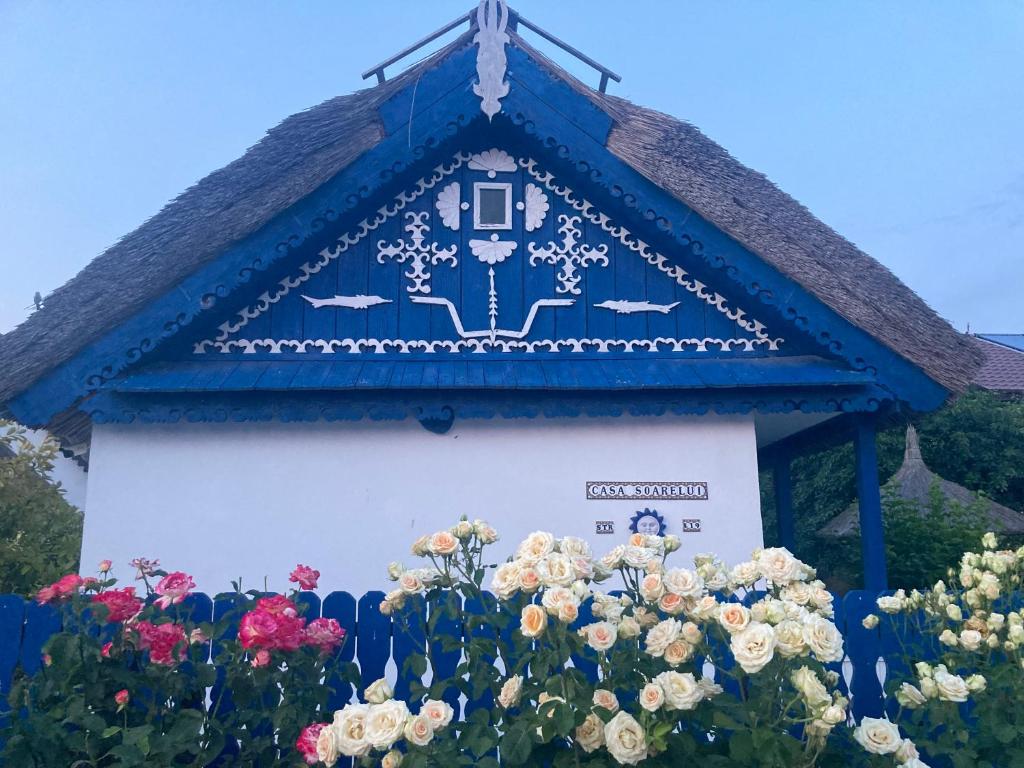 穆里吉奥尔Casa Soarelui的蓝色和白色的建筑,前面有鲜花