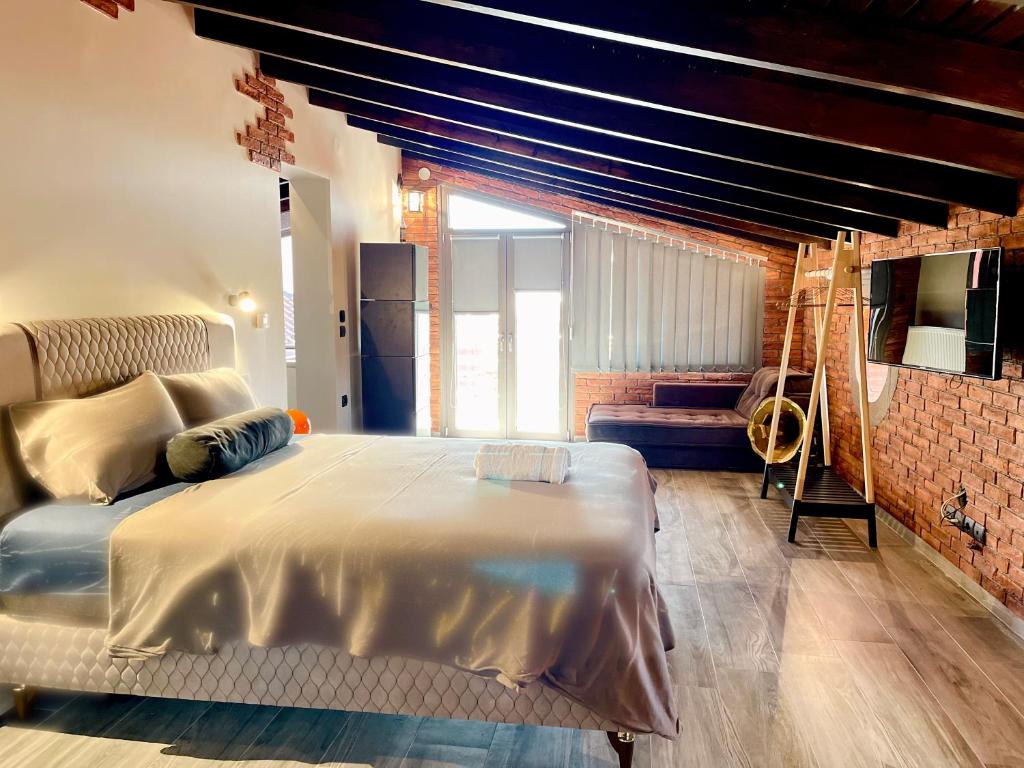 亚历山德鲁波利斯Makri Sunrise Villa的一间卧室设有一张大床和砖墙