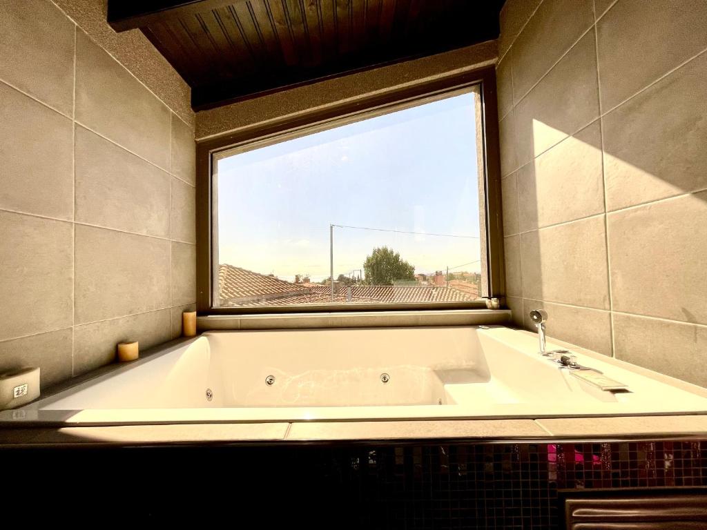 亚历山德鲁波利斯Makri Sunrise Villa的带浴缸的浴室和窗户