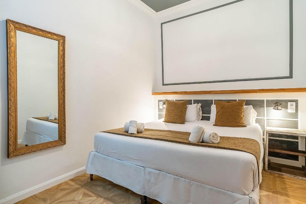 巴塞罗那Casa Gracia Apartments的一间卧室配有一张带镜子的大床