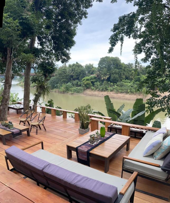 琅勃拉邦占城河景月光酒店的甲板上设有沙发和桌子,享有河景
