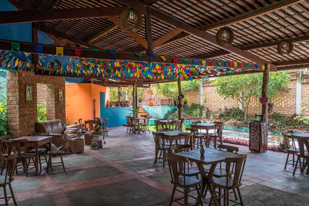 卡鲁阿鲁JasmiManga Pousada的庭院配有桌椅和色彩缤纷的旗帜