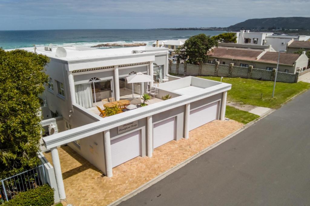 赫曼努斯Hermanus Beachfront Lodge - Solar Power的背景中海洋的房屋的空中景观
