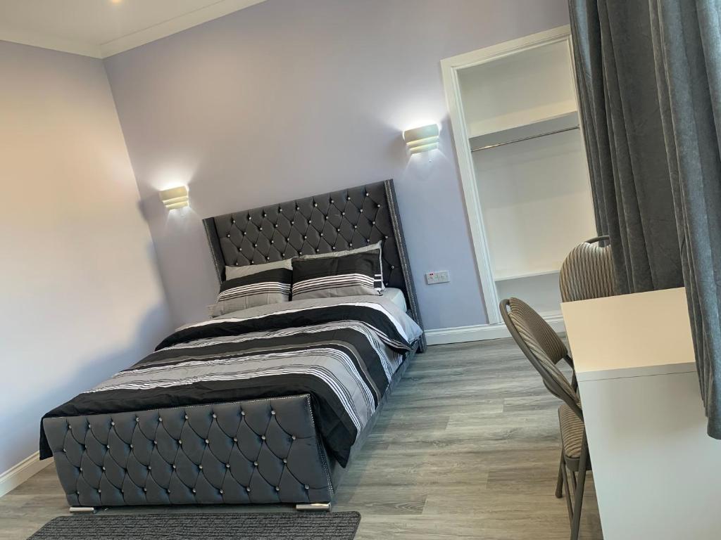 格拉斯哥Ibrox Argyll Sky Suite的一间卧室配有一张带黑色床头板的床