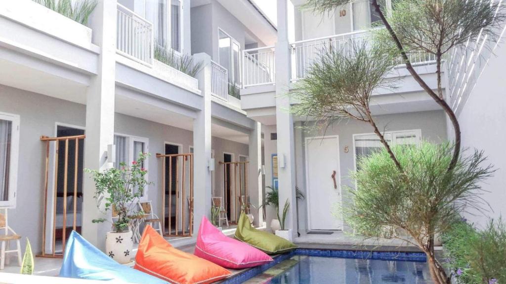 吉利特拉旺安Mantra Gili的游泳池旁的一栋带色彩缤纷枕头的建筑