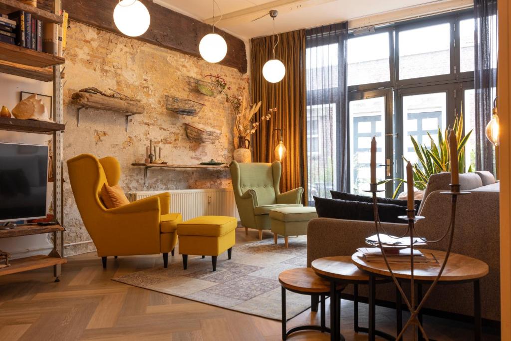 哈莱姆PASSAGE - historic boutique suite的客厅配有黄色椅子和电视