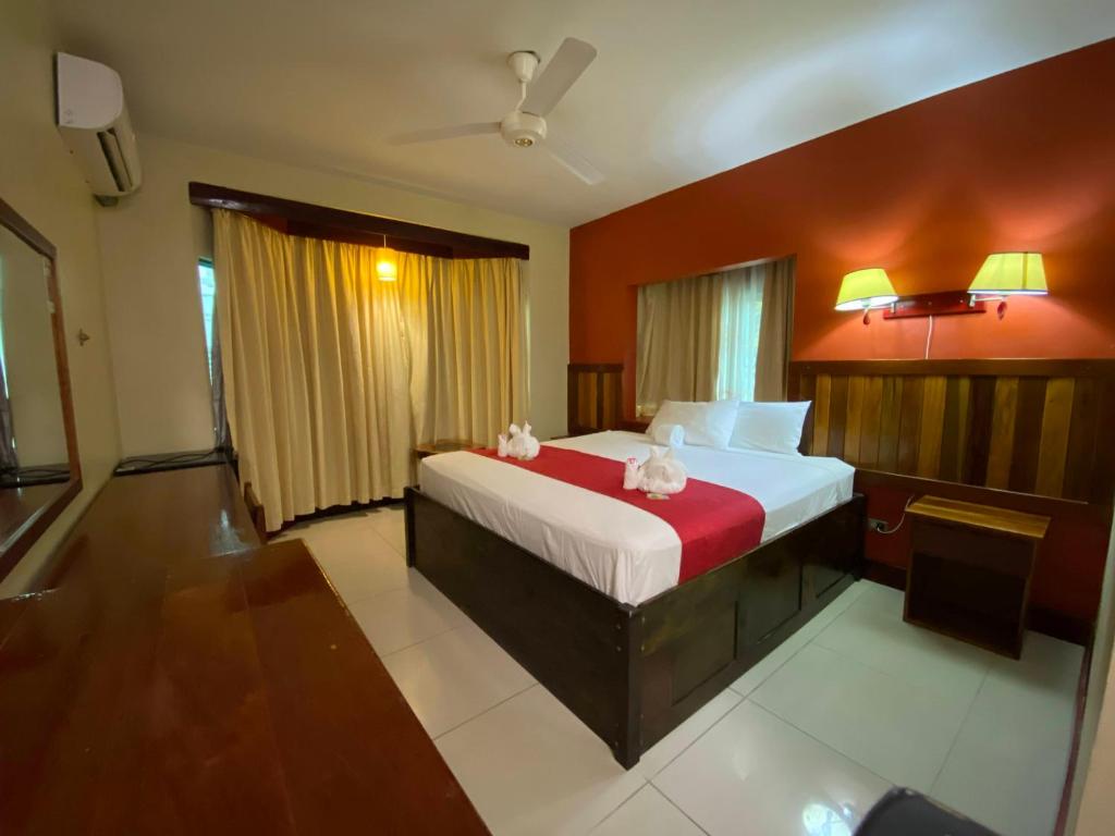 库尔克岛Caye Caulker Plaza Hotel的一间卧室配有一张红色墙壁的床