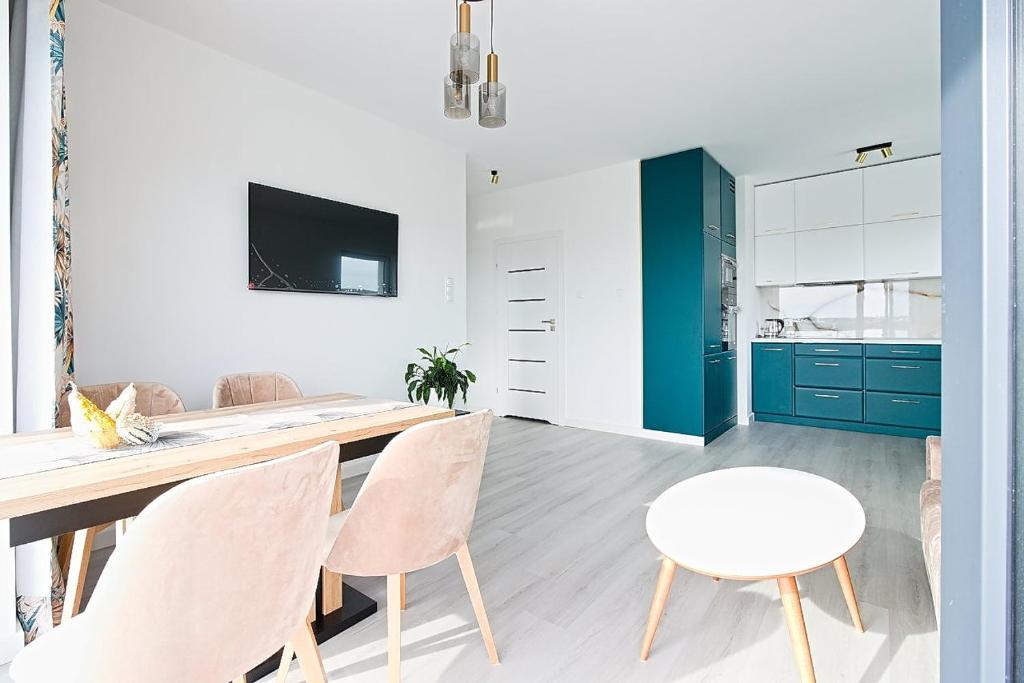 埃尔布隆格Varsovia Residence apartament 17 Parking的厨房以及带桌椅的用餐室。