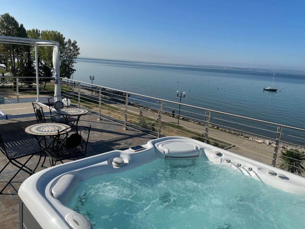 巴多利诺Bardolino Luxury的水边的庭院设有按摩浴缸