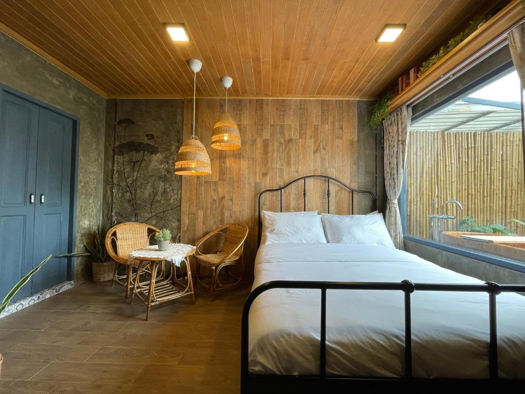 曼谷Central Old Town Cottage的一间卧室配有一张床、一张桌子和一个窗户。