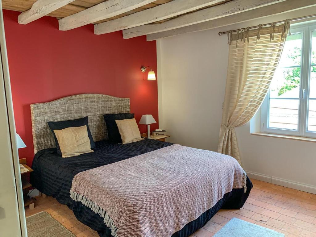 丰特夫罗拉拜Fontevraud Les Chambres的一间卧室设有一张床和红色的墙壁