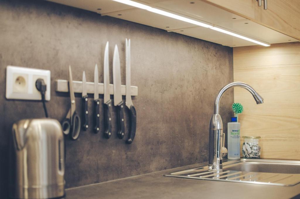布尔诺Oltec Apartment Brno的厨房台面上设有水槽和刀子,墙上设有