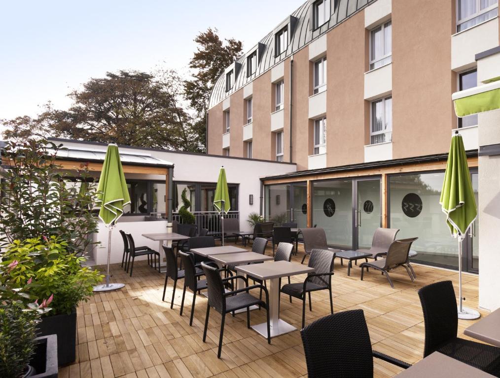 博讷博恩中心宜必思尚品酒店的一座配有桌椅的庭院和一座建筑
