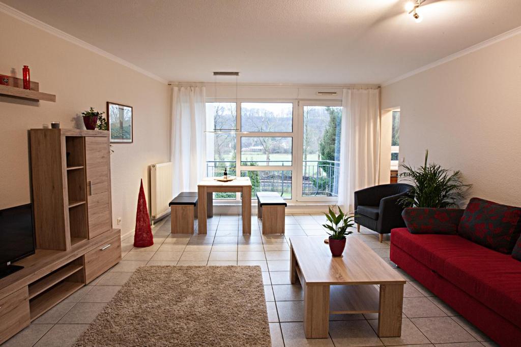 埃森埃森斯穆克斯图克公寓的客厅配有红色的沙发和桌子