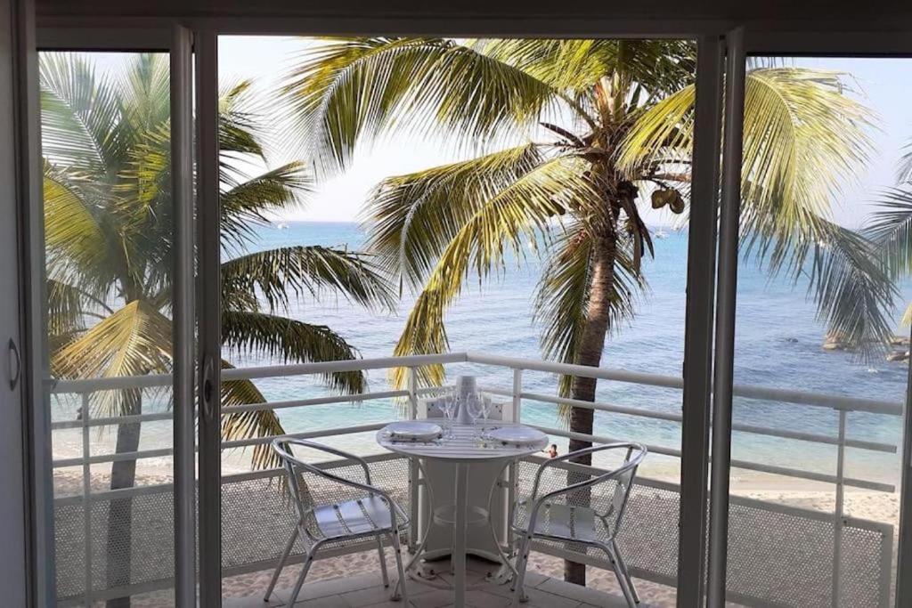 圣马丁岛SeaBird Studio的俯瞰海滩的阳台配有桌椅