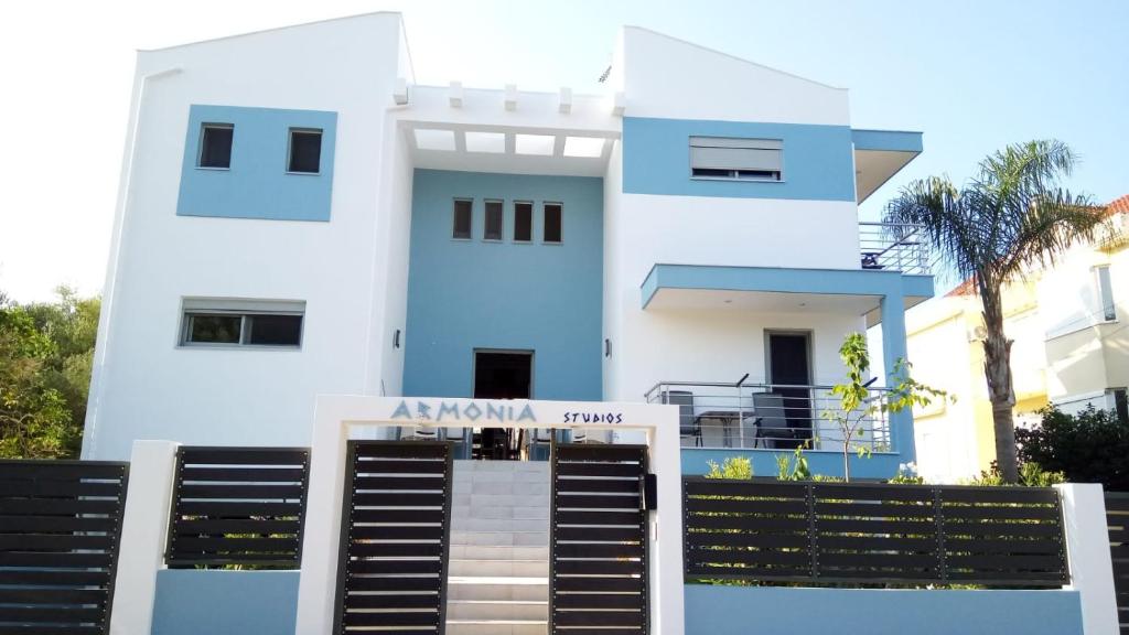 普雷韦扎Armonia Studios Preveza的白色和蓝色的房子,前面有标志