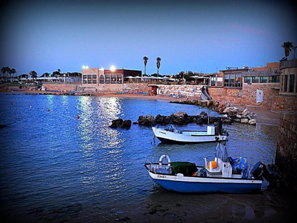 凯撒利亚Caesarea Vacation Rooms的两艘船停靠在一排水中