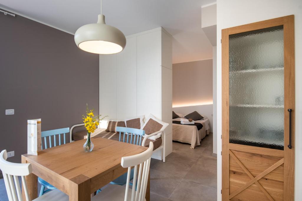 锡罗洛Dietro L'angolo Appartamenti的用餐室以及带木桌和椅子的客厅。