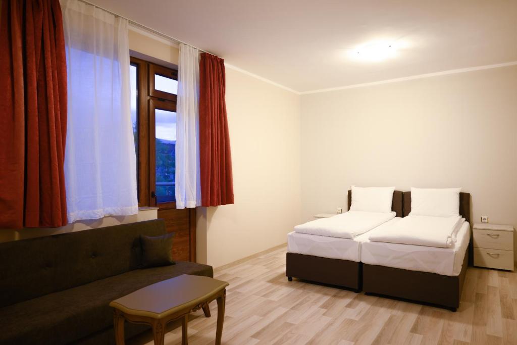索非亚Hotel Leda的一间卧室设有两张床、一张沙发和一个窗口