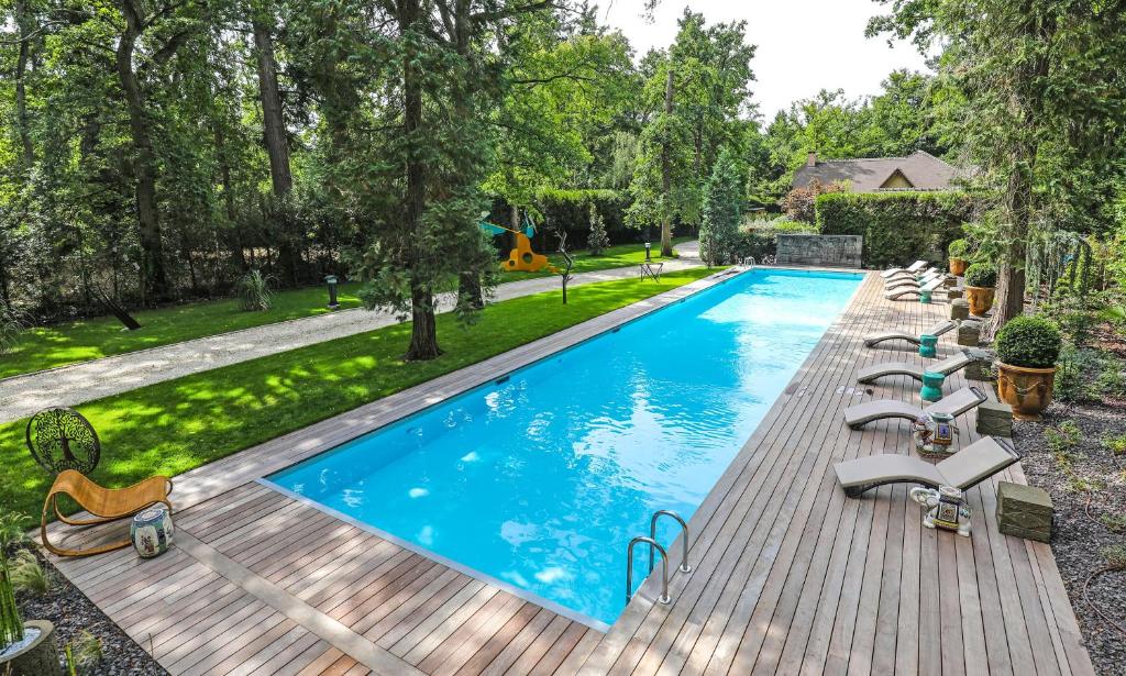 拉莫赫莱The Iflissen Pavilion - Luxury Villa的木甲板上游泳池的形象,带躺椅
