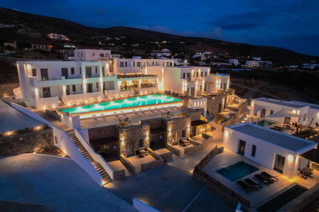 普恩达Kouros Blanc Resort & Suites的享有大楼空中景色,晚上设有游泳池