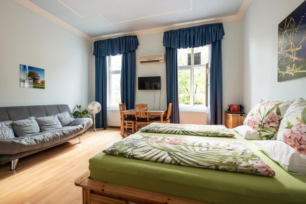 维也纳普利马维拉酒店的一间卧室配有一张床和一张沙发
