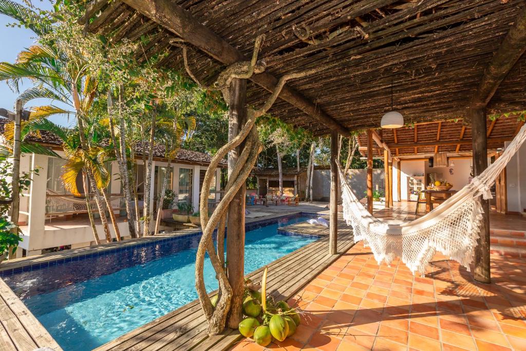 托兰克索Casa Caminho do Mar (TRANCOSO-BA)的一个带吊床和游泳池的度假村