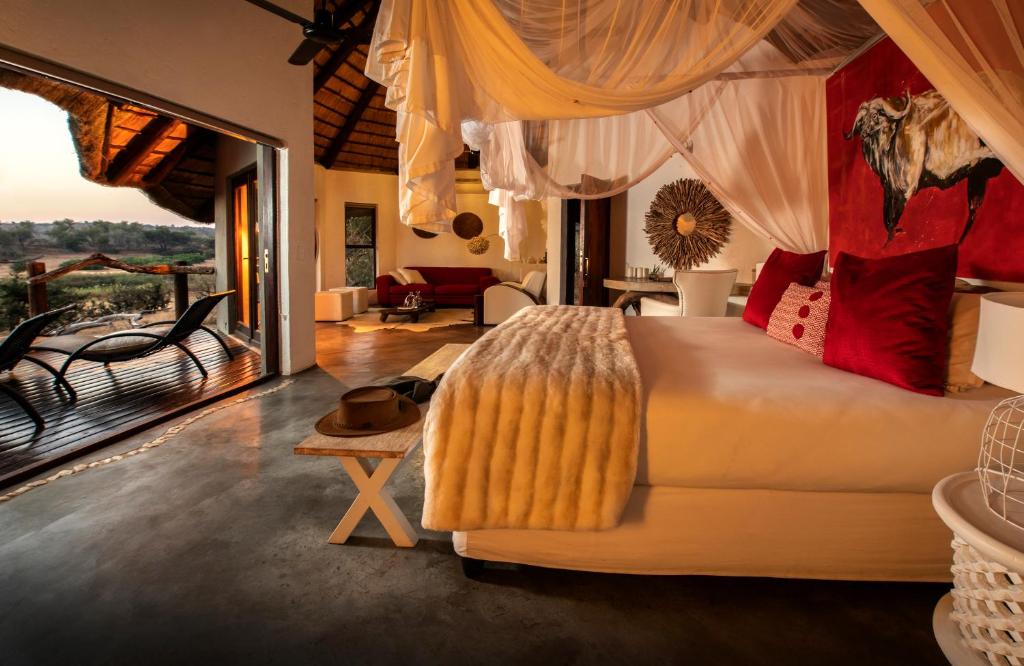 巴卢莱自然保护区Pondoro Game Lodge的一间卧室设有一张床和一间客厅。