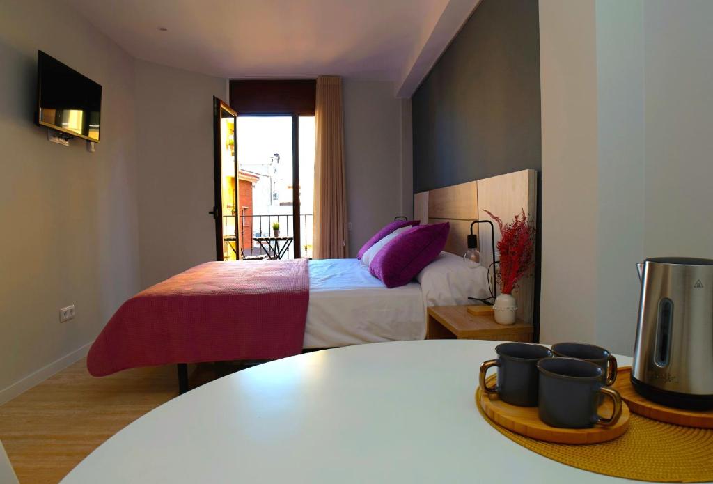巴达洛纳Can Mir Badalona的一间卧室配有一张带紫色枕头的床和一张桌子