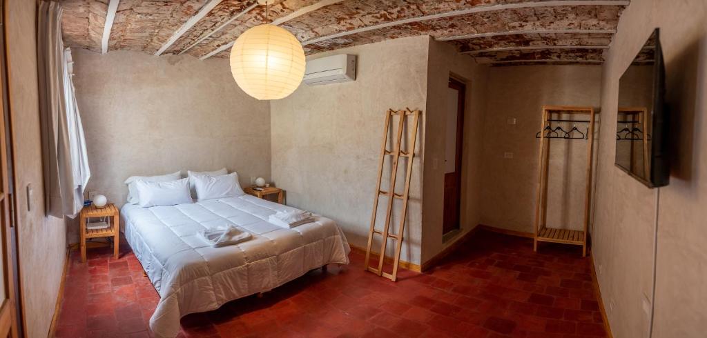 罗萨里奥Hotel Casa Allegra Art Suites的卧室配有白色的床