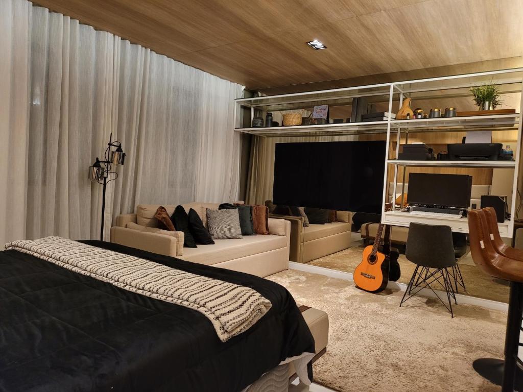 圣保罗Hotel Bourbon Ibirapuera Suite 5 estrelas Moema的一间卧室配有一张床、一张沙发和一张书桌