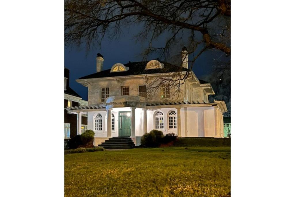 查尔斯顿Grand Old White Capitol Executive Suite的白色的房子,晚上有绿门