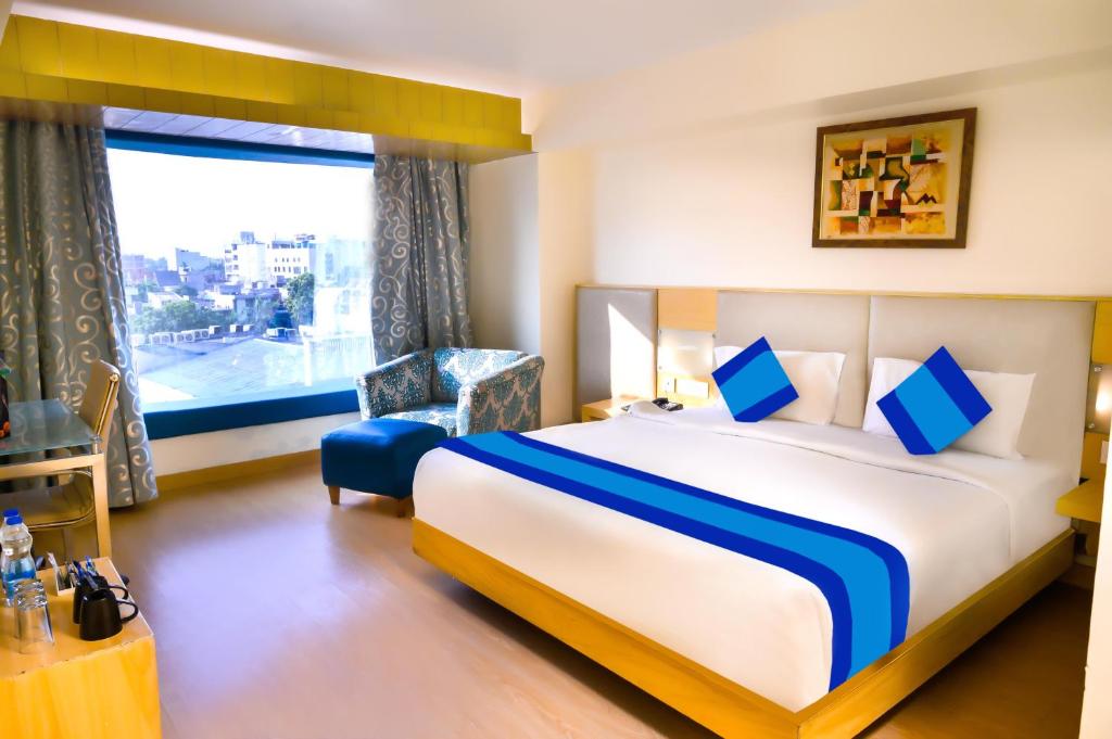 阿姆利则Keyonn Hotels & Resorts的一间设有大床和窗户的酒店客房