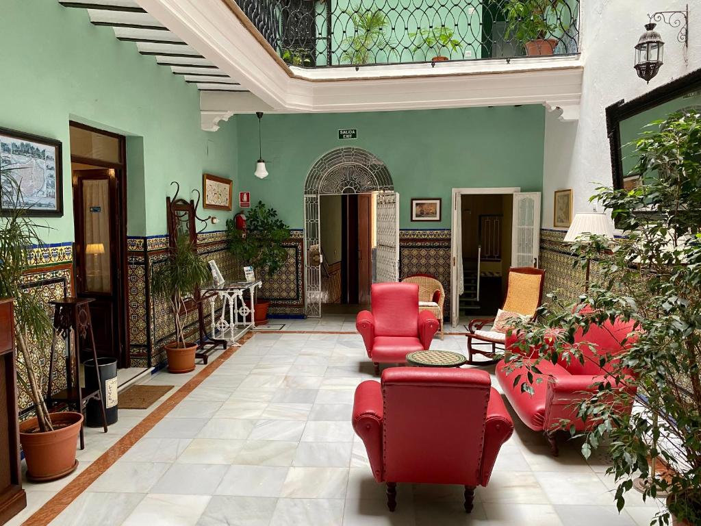 加的斯西班牙膳食公寓的大型客厅配有红色家具和植物