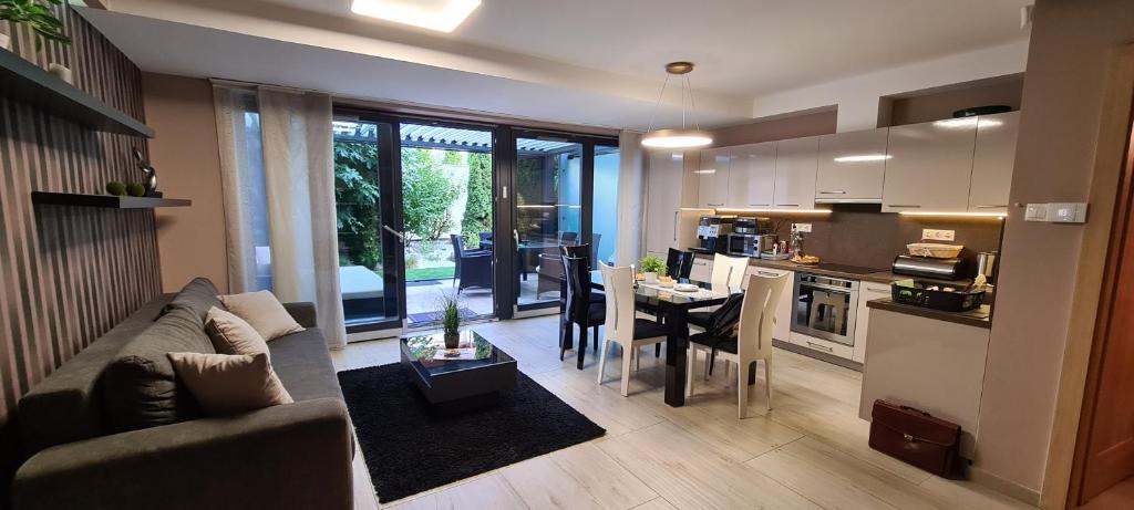 巴拉顿菲赖德Villapark Pleasure Apartment的客厅以及带沙发和桌子的厨房。