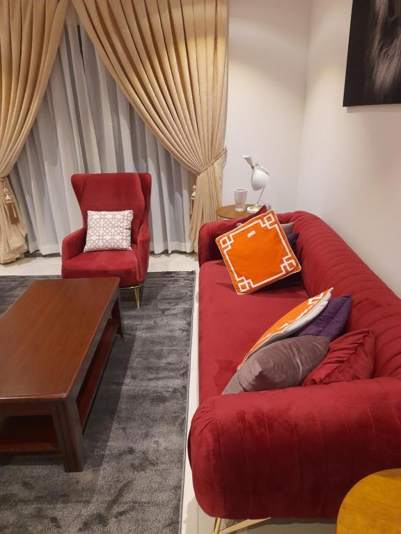 阿克拉The Lennox D-Plus Apartments的客厅配有红色的沙发和椅子