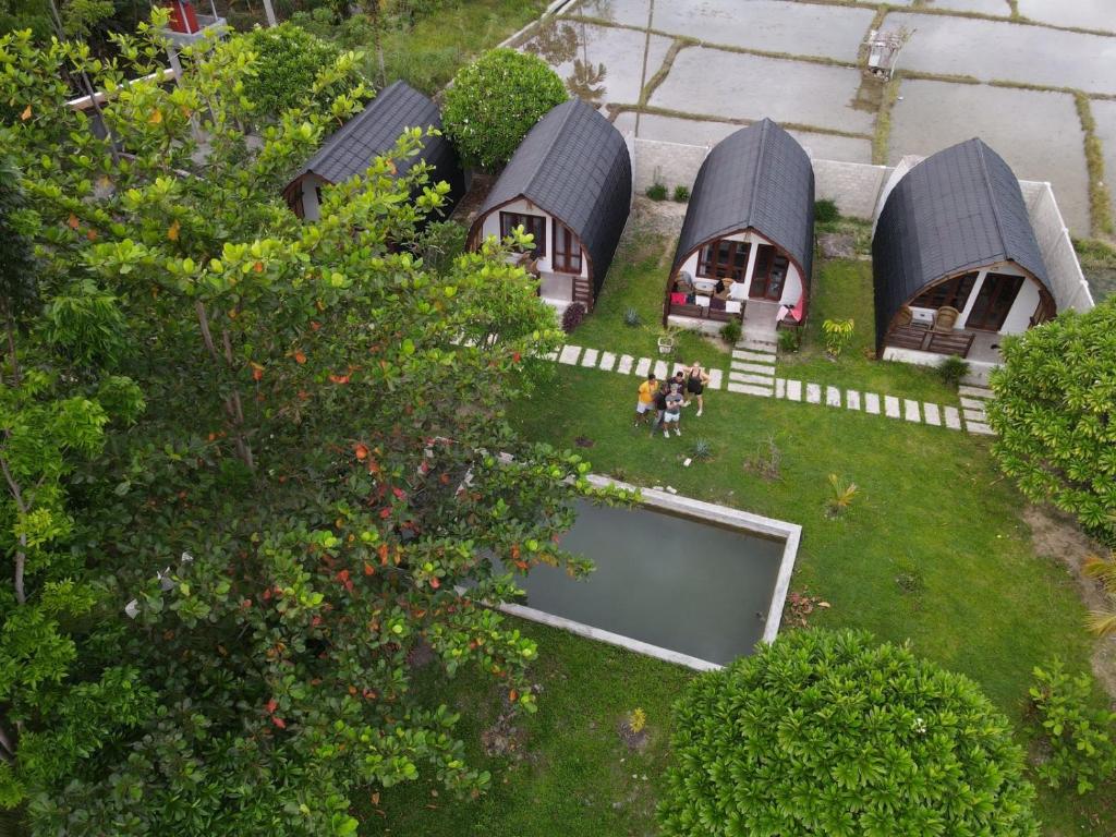 武吉拉旺Gino's Place - Bungalows and Restaurant的站在院子中的人的房屋的空中景观