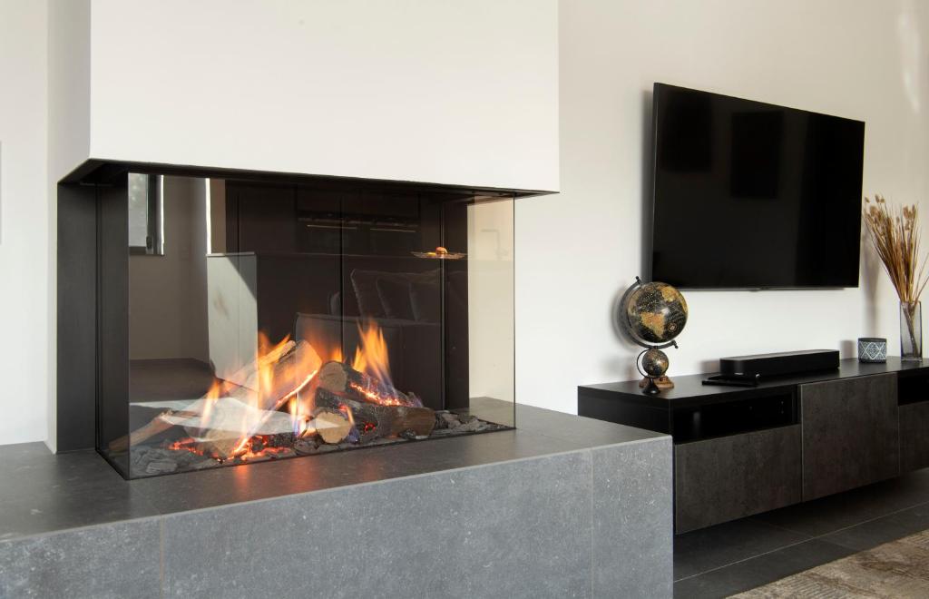 HauLuxus Penthouse mit Kamin und Sonnenterasse的客厅设有壁炉和电视。
