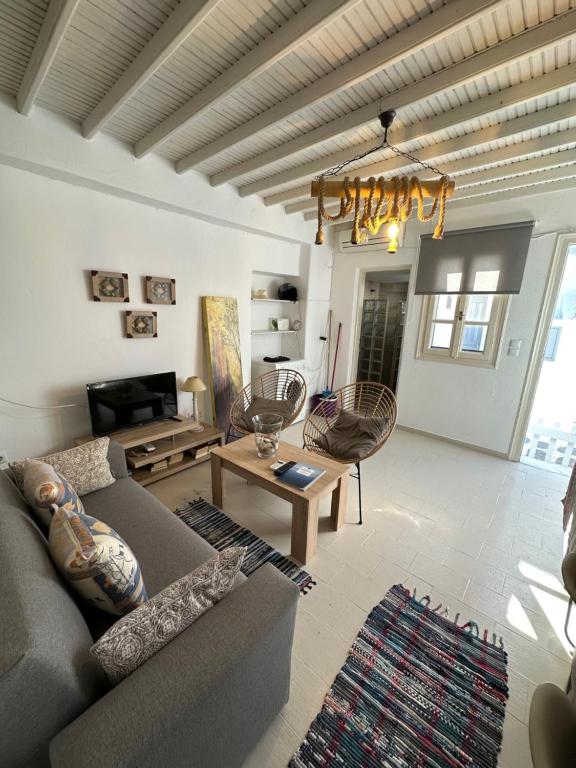Megali AmmosMyconian Avra Apartment的客厅配有沙发和桌子