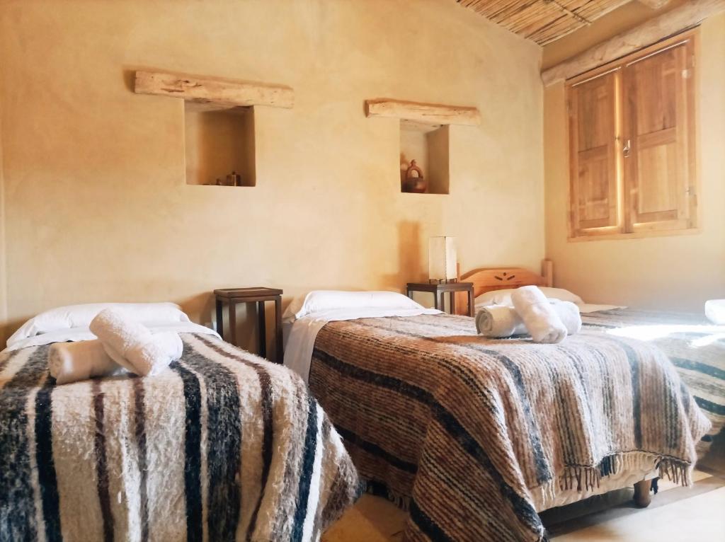 蒂尔卡拉La Elegida的一间设有两张带毯子的床的房间