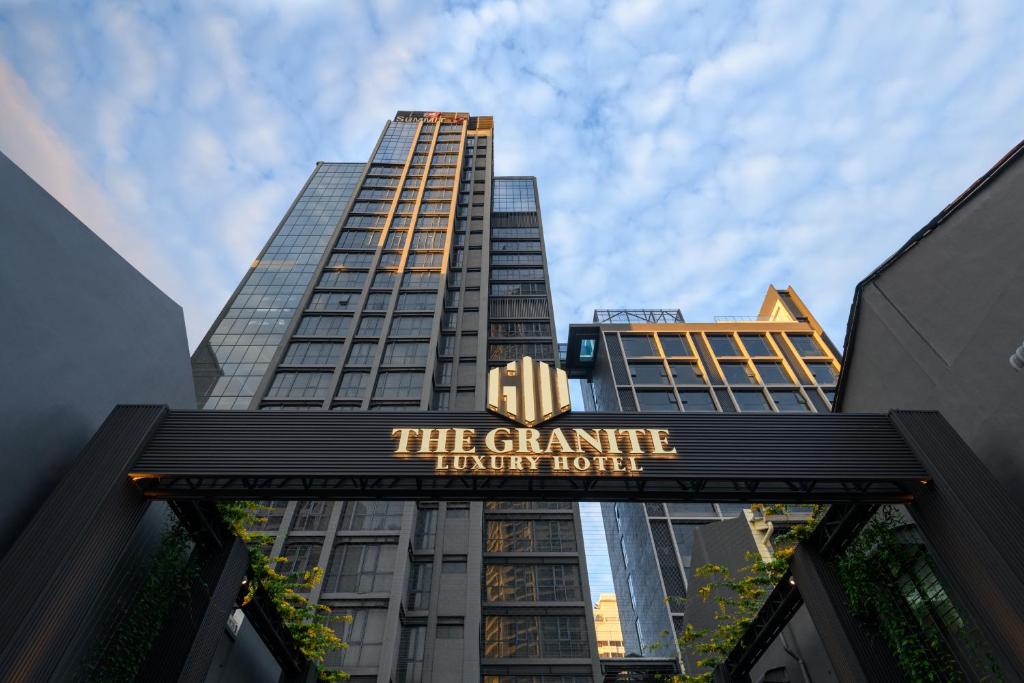 乔治市The Granite Luxury Hotel Penang的一座高楼前的宏伟转折酒店的标志